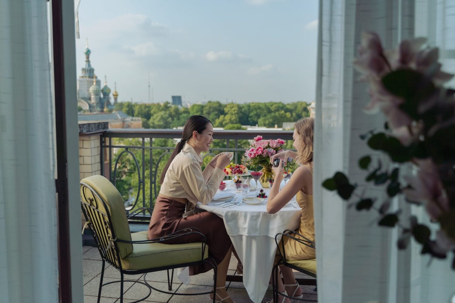 women having dinner at the balcony while having conversation