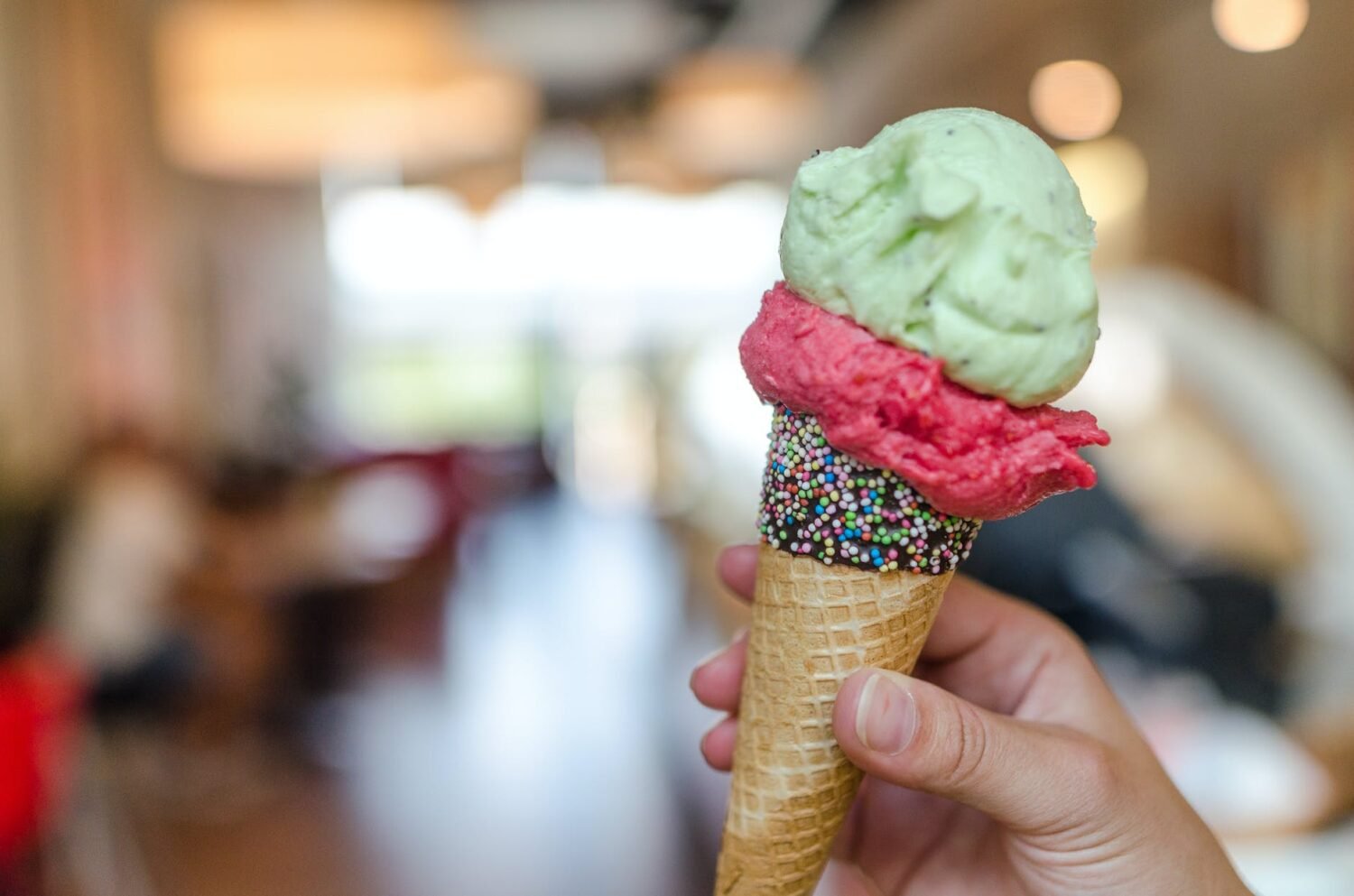 close up photo of person holding assorted flavor ice cream on cone